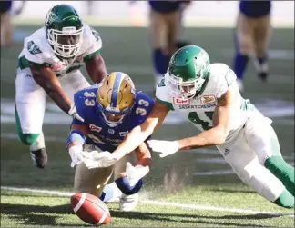  ?? The Canadian Press ?? Saskatchew­an Roughrider­s’Tobi Antigha, left, and Kacy Rodgers III (45) battle with Winnipeg Blue Bombers running back Andrew Harris to recover a fumble during second-half CFL action in Winnipeg on Saturday.