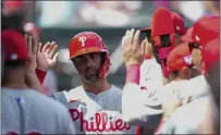  ?? RICH STORRY — GETTY IMAGES ?? The Phillies’ Whit Merrifield celebrates after scoring against Miami during the first inning on Saturday in Jupiter, Florida. Merrifield had two hits and drove in two runs as the teams tied, 3-3.