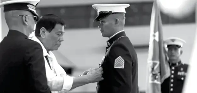  ?? (Presidenti­al Photo) ?? MANILA. President Rodrigo Roa Duterte confers the Order of Lapu-Lapu Kamagi Medal and the Bronze Cross Medal on SSGt. Antonio Diva during the 67th anniversar­y of the Philippine Marine Corps at the Bonifacio Naval Station in Fort Bonifacio, Taguig City...