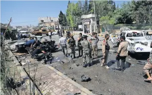  ?? Reuters ?? Free Syrian Army members inspect damaged cars following a car bomb blast that killed one person in Azaz, Syria, on Saturday. —