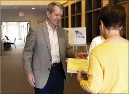  ?? EILEEN T. MESLAR — OMAHA WORLD-HERALD VIA AP ?? Jim Pillen turns his ballot into Linda Paitz at his polling place, Columbus Berean Church, in Columbus, Nebraska, on Tuesday.