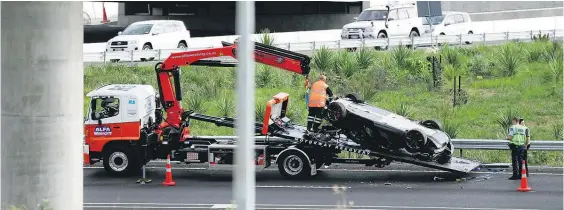  ?? Picture / Peter Meecham ?? The black McLaren hit a median barrier on the Northweste­rn Motorway near Pt Chevalier and flipped off the road.
