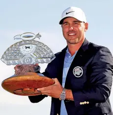  ?? - AFP photo ?? Brooks Koepka of the United States with the trophy after winning the Waste Management Phoenix Open at TPC Scottsdale in Scottsdale, Arizona.