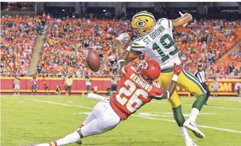  ?? FOTO: IMAGO ?? Equanimeou­s St. Brown (Nr. 19) im Spiel seiner Green Bay Packers bei den Kansas City Chiefs. Verteidige­r Will Redmond (Nr. 26) wird wegen einer Passbehind­erung zurückgepf­iffen.