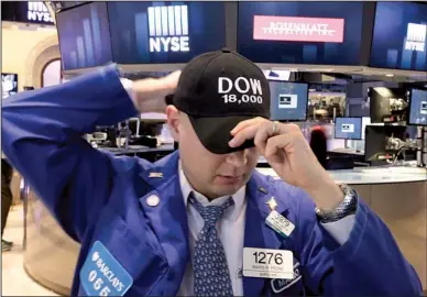  ?? AP/RICHARD DREW ?? Specialist Mario Picone adjusts his Dow 18,000 cap while working Friday on the floor of the New York Stock Exchange. The Dow Jones industrial average drew within 10 points of 18,000 during trading Friday.