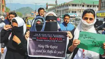  ?? PTI ?? Students hold placards during a protest demanding justice for 8-year-old Asifa who was raped and murdered in Kathua, in Srinagar yesterday.