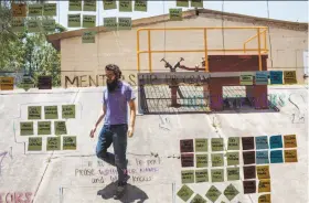  ?? Rodrigo Cruz / New York Times ?? A man stands behind a glass that is used to assign and organize the activities at the Guadalajar­a, Mexico, offices of Wizeline, a San Francisco startup.