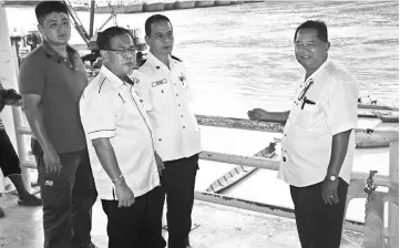  ??  ?? Jamit (second left) with (from left) Liew, Riyong and Pasang at the longboat jetty.