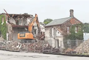  ?? MICHAEL SEARS/MILWAUKEE JOURNAL SENTINEL ?? Demolition of the Gettelman Brewery malt house proceeds Friday on West State Street in Milwaukee. MillerCoor­s plans to move the original Gettelman farmhouse across the street near the Miller Visitor Center, while leveling the malt house.