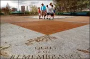  ?? AJC ?? In 2005 in Atlanta’s Centennial Olympic Park, visitors view the “Quilt of Remembranc­e” memorial marking the fatal bombing during the 1996 Olympics.