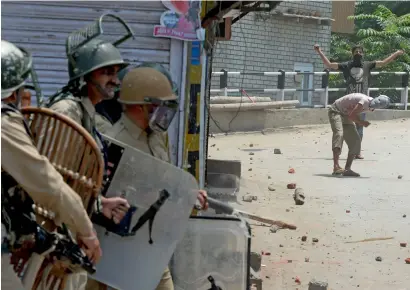 ?? AFP ?? Protesters throw stones at government forces during clashes in Srinagar on Saturday. —