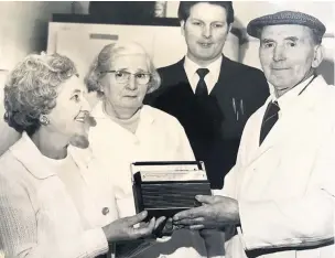  ??  ?? George receiving a gift upon his retirement from his market stall in Hanley.