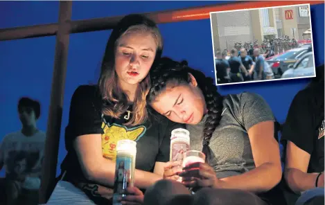  ??  ?? Melody Stout and Hannah Payan comfort each other during a vigil for victims of the shooting on Saturday.