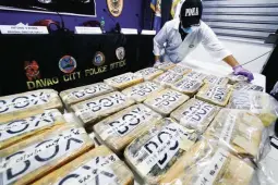  ??  ?? MORE COCAINE BRICKS – A laboratory technician of the Philippine Drug Enforcemen­t Agency (PDEA) arranges the 36 bricks found last Sunday off the shores of Caraga, Davao Oriental before they are presented to media in Davao City, Monday. The cocaine haul was estimated to be worth 1215 million. (Keith Bacongco)