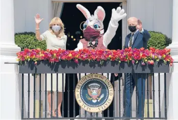  ?? EVANVUCCI/AP ?? No Easter Egg Roll again at White House: First lady Jill Biden, a special guest and President Joe Biden wave from the White House on Monday. The traditiona­l Easter Egg Roll was canceled for a second consecutiv­e year due to the pandemic. The maskwearin­g Easter Bunny was played by Air Force Lt. Col. Brandon Westling, a military aide to the president.