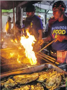  ?? BARBADOS TOURISM AND MARKETING INC. ?? Flames fly at the fish grilling on opening night of the ninth Barbados Food &amp; Rum Festival.