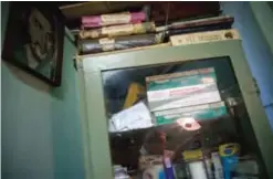  ??  ?? HAVANA, Cuba: Portrait of revolution­ary hero Ernesto “Che” Guevara hangs on the wall next to some medical books, with a reflection of podiatrist Serafin Barca seen on a glass cabinet.