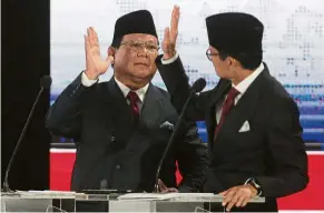  ??  ?? All the best: Prabowo (left) and his running mate Sandiaga Uno at a televised presidenti­al candidate debate in Jakarta. — AP