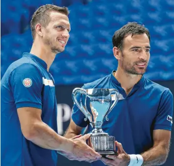  ?? Foto: Mark Dadswell, dpa ?? Filip Polasek (links) und Ivan Dodig strahlen über das ganze Gesicht, als sie den Sieger‰Pokal bei den Australian Open entgegen‰ nehmen. Beide sind in der kommenden Saison beim Tennis‰Zweitligis­ten TC Augsburg gemeldet.