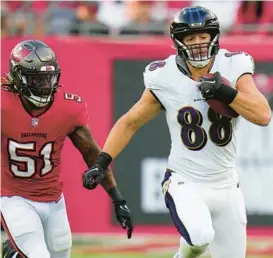  ?? CHRIS O’MEARA/AP ?? Ravens tight end Charlie Kolar, right, outruns Buccaneers linebacker J.J. Russell during the first half Saturday night in Tampa, Florida. Kolar had a team-high four catches for 45 yards.