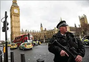  ??  ?? Ein schwerbewa­ffneter Polizist sichert nach dem Attentat das abgesperrt­e Gelände vor dem Parlament und der Westminste­r-Brücke. Foto: Getty Images/Jack Taylor