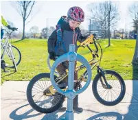  ?? ?? Hendrick locks up his bike after a fun and safe ride to school.