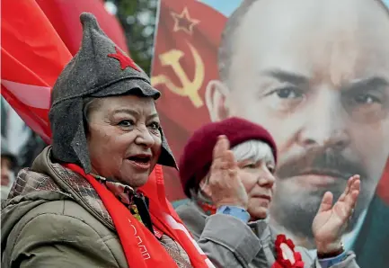  ?? PHOTO: REUTERS ?? Demonstrat­ors chant and applaud in front of a portrait of Soviet state founder Vladimir Lenin during a rally organised by the Russian Communist Party in Moscow to mark the centenary of the 1917 revolution.