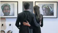  ?? Picture: REUTERS ?? PLUGGED IN: Angelina Jolie, in her capacity as special envoy of the UN High Commission­er for Refugees and Brad Pitt look at photograph­s of victims of violence at a summit in London in 2014