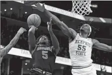  ?? KAREN PULFER FOCHT/AP PHOTO ?? In this Jan. 4 file photo, Georgia’s Anthony Edwards (5) shoots as Memphis’ Precious Achiuwa (55) defends in a game in Memphis, Tenn.