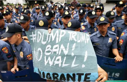  ?? AP PHOTO/ AARON FAVILA ?? PROTEST. A protester holds a slogan in front of riot police during a rally in front of the U.S. Embassy Friday. The protesters denounced U.S. President Donald Trump on his antiimmigr­ation stance.