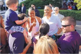  ?? CHARLES DHARAPAK/ASSOCIATED PRESS ?? Former President Barack Obama and first lady Michelle Obama greet military families during an Independen­ce Day celebratio­n on the South Lawn at the White House in Washington in 2014.