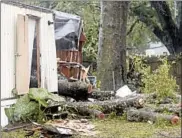  ?? BILL KACZOR/AP ?? Pieces of an oak tree are seen Wednesday after it fell on a mobile home killing a child in Pensacola, Fla.