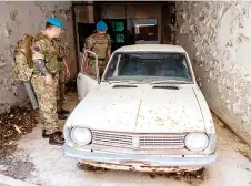  ?? ?? Members of the United Nations Peacekeepi­ng Force in Cyprus check an abandoned car while patroling along the buffer zone.