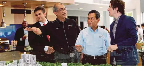  ?? [ FOTO /ZULKARNAIN AHMAD TAJUDDIN/BH ] ?? Ismail (dua dari kanan) bersama Khairil Anwar (tiga dari kanan) melihat replika projek pembanguna­n Medini selepas melancarka­n Malaysia Biennial 100YC di Johor Bahru, semalam.