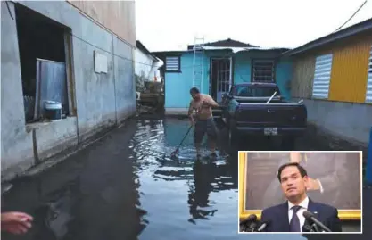  ?? — AFP photos ?? CATANO: At nightfall a man tries to clean the yard next to his house damaged by Hurricane Maria. (INSET) Sen Marco Rubio takes questions from reporters about the relief effort in Puerto Rico following Hurricane Maria, September 26, 2017 at the US...