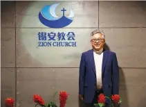  ?? REUTERS ?? THE HEAD PASTOR of the Zion church in Beijing, Jin Mingri, poses in the lobby of the unofficial Protestant ‘house’ church in Beijing in this Aug. 28 photo.