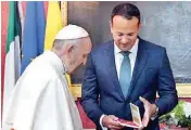  ??  ?? Pope Francis (L) exchanges gifts with Irish Prime Minister Leo Varadkar (R) in St Patricks Hall in Dublin Castle on Saturday, during his visit to Ireland to attend the 2018 World Meeting of Families