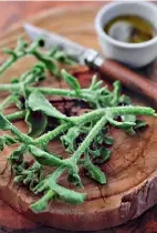  ??  ?? Clockwise from top: Chef Kobus van der Merwe forages for ingredient­s to use at Wolfgat, his restaurant in Paternoste­r; soutslaai, a local plant, served with vinaigrett­e; minced limpet with white wine, lemon, butter, and nutmeg.