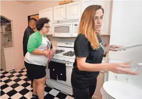  ?? RICK WOOD / MILWAUKEE JOURNAL SENTINEL ?? From left, Tan Ho, Amanda DoAmaral and Claire McHale get ready for dinner in their kitchen.