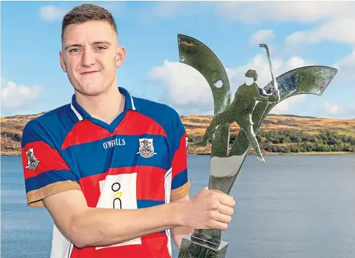  ??  ?? WINNING FEELING: Kingussie captain Robert Mabon shows off the Mowi Premiershi­p Trophy on the shores of the Kyles of Bute