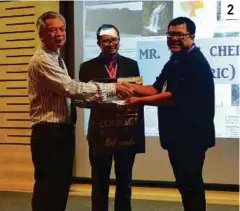  ??  ?? 2 2. Eric Tang Cher Hing collecting his prize for winning the image research competitio­n with a poster of the Orchidacea­e at Ayer Hitam Forest, Threats and Conversati­on.