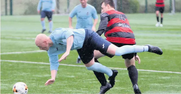  ??  ?? Menai Bridge striker Dean Redmond (light blue) may be taking a tumble here but he kept his composure perfectly in scoring four goals against CPD Y Fali last Saturday.