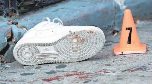  ?? THEODORE PARISIENNE | FOR NEW YORK DAILY NEWS ?? Blood stains the street after a 6-year-old boy was shot in Brooklyn in September. Below, cops investigat­e multiple shooting over the weekend. The city has seen twice the number of shooting victims this year as last year.