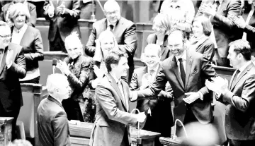  ?? — Reuters photo ?? Trudeau shakes hands with Edouard prior to delivering a speech at the National Assembly in Paris, France.