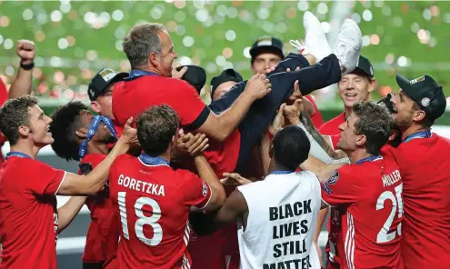  ?? FOTO: MIGUEL A. LOPES / AFP ?? Bayern-Trainer Hans-Dieter Flick wird von seinen Spielern nach dem Champions-League-Triumph gebührend gefeiert.