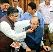  ??  ?? Union Ministers Arun Jaitley and Ravi Shankar Prasad celebrate the passage of the GST Bill through the Rajya Sabha on Wednesday in New Delhi.