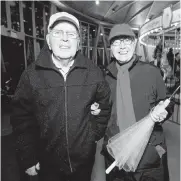  ??  ?? Ron and June Bellows took shelter from the rain in the Rose Carousel building.