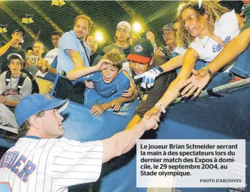  ??  ?? Le joueur Brian Schneider serrant la main à des spectateur­s lors du dernier match des Expos à domicile, le 29 septembre 2004, au Stade olympique.