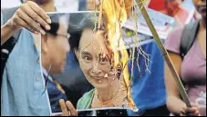  ?? AP ?? Activists burn a poster of Suu Kyi in Kolkata on Monday.