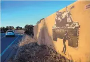  ?? EDDIE MOORE/JOURNAL ?? Artwork depicting Palestinia­ns clashing with Israeli soldiers recently installed on an east side Santa Fe home’s adobe wall will be the subject of a hearing.